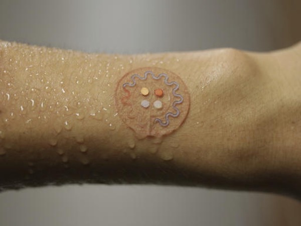 This photo provided by J. Rogers, Northwestern University, shows a soft, skin‐mounted microfluidic device for capture, collection and analysis of sweat. Time to break a sweat: Researchers are creating a skin patch that can test droplets of sweat to track health while people exercise, beaming results to their smartphones. (J. Rogers, Northwestern University via AP)