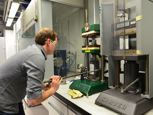 Scientist compressing nanopowder with hydraulic press
