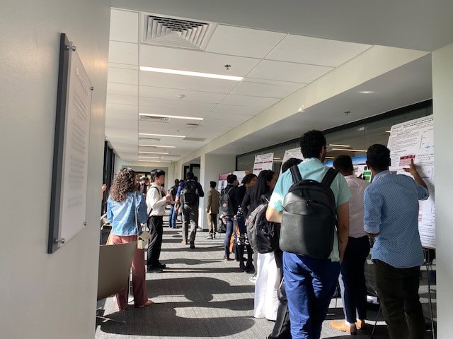 Attendees at the Advances in Cement-Based Materials conference view research posters in a hallway.