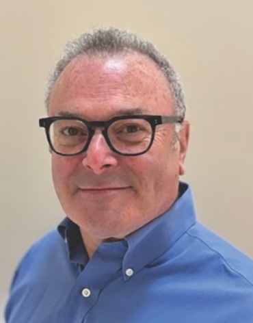 Headshot of a man wearing glasses and a blue shirt.