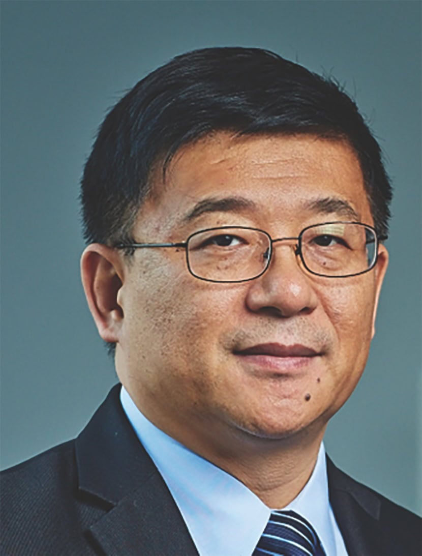 Headshot of a man wearing glasses and a blue shirt.