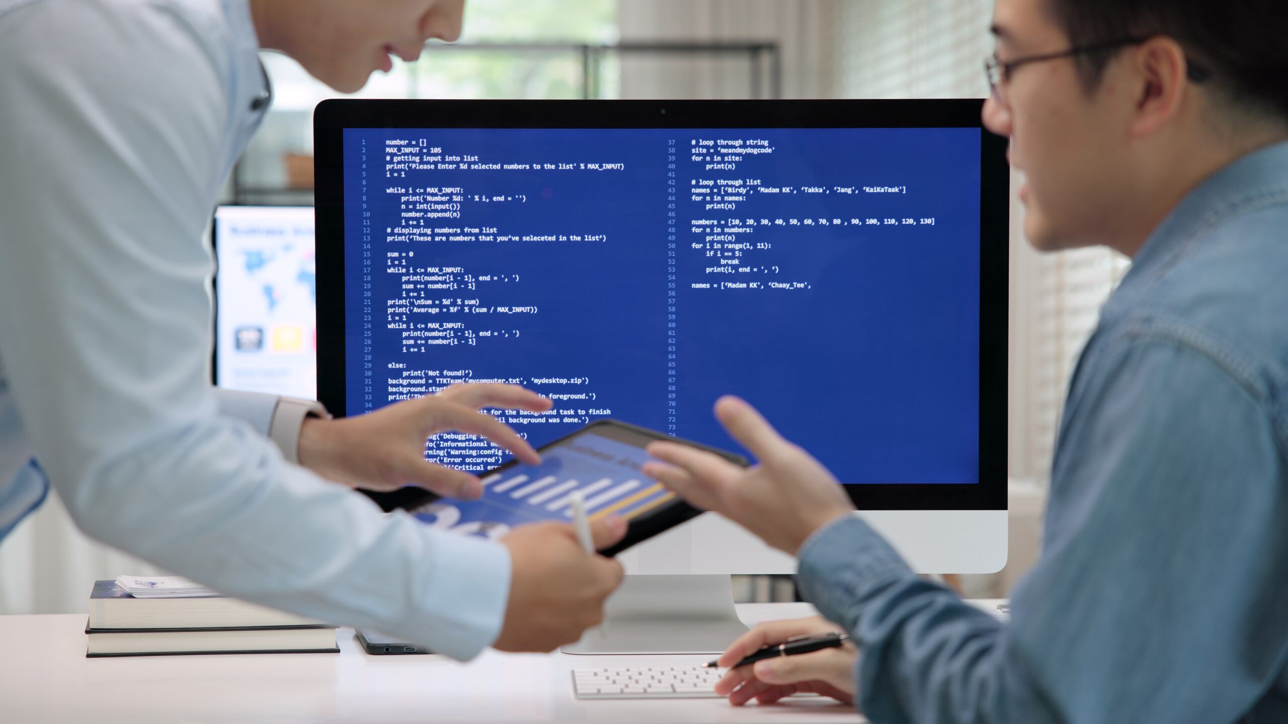 Two people analyzing code on a computer monitor, AI course for engineers